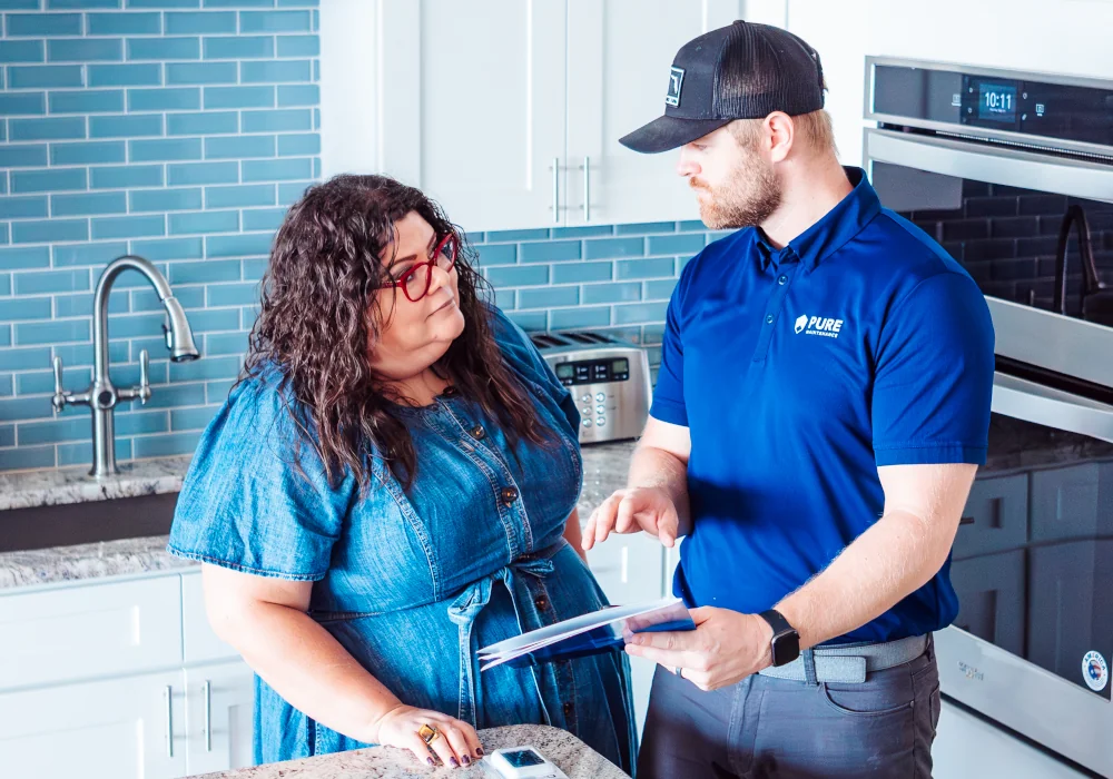 mold remediation and water damage restoration technician in jacksonville, florida explaining a mold removal quote to a homeowner in her kitchen